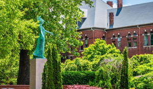 Photo of Minerva status against wooded background on UNCG campus