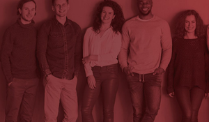 Various people standing against a plain background